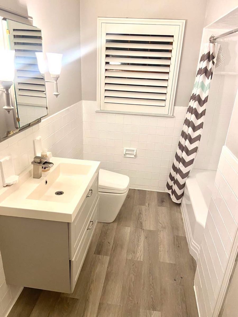 White tiled bathroom with a floating vanity